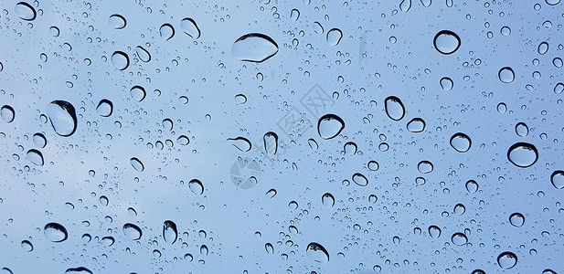 抖音控雨素材通过窗玻璃表面对蓝色天空的窗口玻璃透视水滴子视角 用于多媒体内容宏观窗户飞沫背景墙纸液体气泡雨滴环境天气背景