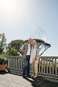 日子只会越来越好 一对快乐的老年夫妇在家里的露台上一起放松背景图片