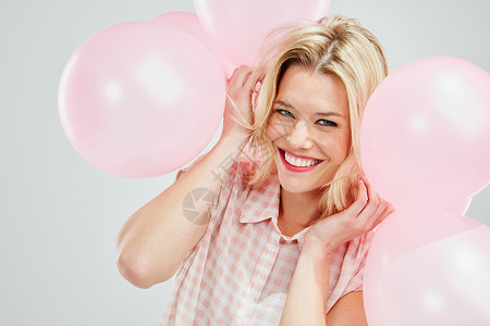 美丽的气球看在爱气球的份上 一个美丽的年轻女人 装着粉色气球背景