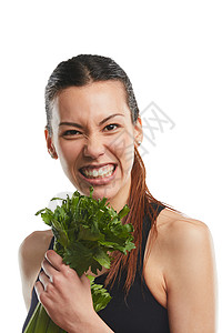你今天吃蔬菜了吗？一个年轻漂亮的女人在白色背景下与芹菜合影的工作室肖像背景图片