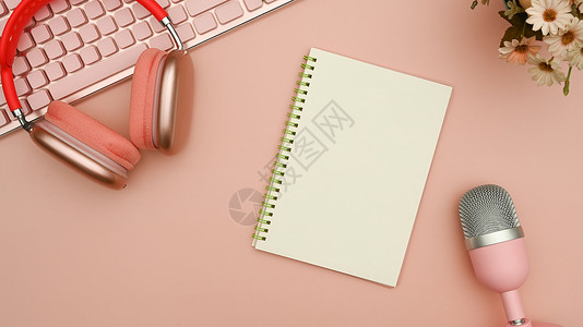 麦克风和耳机上面的无线耳机 播客麦克风和粉红色背景上的注纸背景