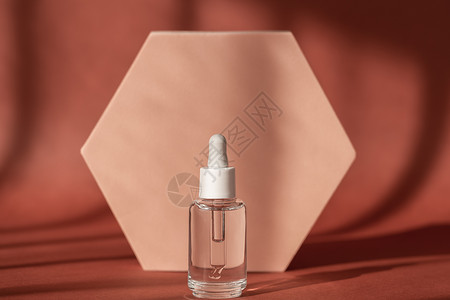 透明质酸 米色讲台基座上的血清护肤瓶 棕色表面带有肽和胶原蛋白的血清产品化妆品 带有阴影的现代品牌包装背景图片