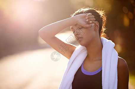 女人在户外密集训练后擦干凈汗水的 她就把汗水擦乾淨了背景图片