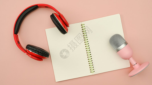 麦克风和耳机红无线耳机和麦克风以及粉红色背景的空纸条 技术和音频设备概念背景