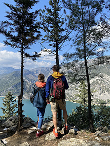 剧情男人和女人旅行者背着背包 在山顶上看峡谷 徒步旅行背景