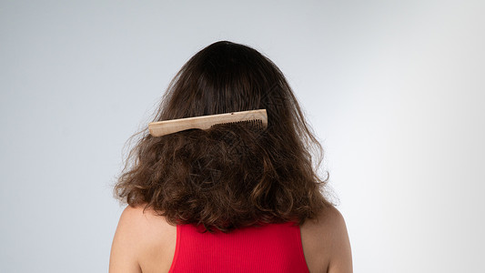 梳子卡在一个女人的毛发上 抓痒问题背景图片