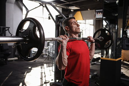 体操馆的男性运动健壮运动员力量杠铃训练健身房健美肌肉男人举重背景图片