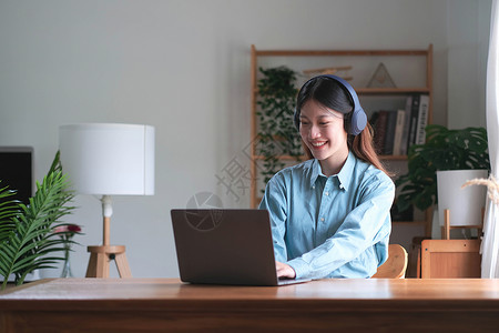 亚洲女学生在线学习班学习在线视频通话 zoom 老师 快乐的亚洲女孩用电脑笔记本电脑在线学习英语电话教育青少年耳机学校图书馆技术背景