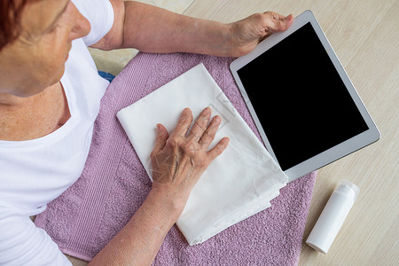 类风湿关节炎一个老年妇女看着平板电脑 寻找信息 复制粘贴物(copypaste)背景