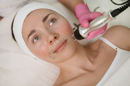 皮肤射频获得皮肤护理美容治疗的有吸引力的妇女化妆师女士皮肤科老化美容师提升沙龙抗衰老射频背景
