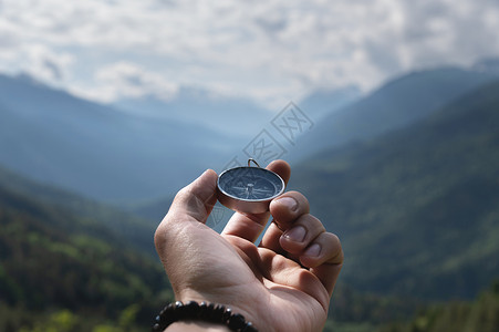 夏季户外云中山脉背景下男性手掌中的磁罗盘 旅行 第一人称视角远足男人看法远足者勘探天空小路游客旅游闲暇背景