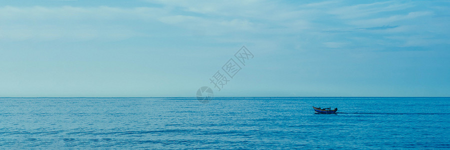 简单背景 冷淡的深蓝海钓渔船 仅白苍白的旋翼云层 无限制无限制开放背景图片