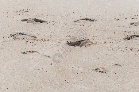 近距离拍摄海滩沙滩上的脚印背景图片