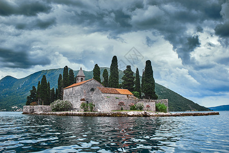 黑山湖边岛屿上的城堡教堂城市石头岩石纪念碑村庄地标全景树木太阳背景图片