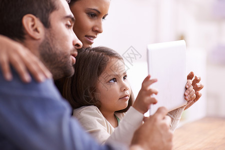 家庭电影时间 一个小女孩和父母在平板电脑上玩耍背景图片