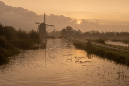 在荷兰里特维尔兹的哈泽斯沃德多尔普风车上 清晨有雾中金色的日出背景图片