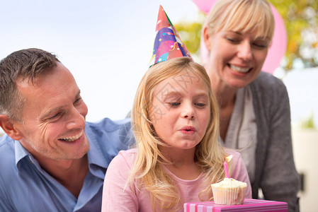 生日愿望生日女孩的愿望 一个快乐的小女孩和她的父母庆祝她生日的裁剪镜头背景