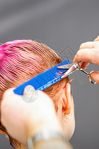 粉色发廊元专业发型师正在剪短粉红色头发 在发廊剪剪刀合上理发理发师客户工作女性白色剪刀梳子粉色剪发背景