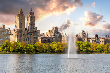 肯尼迪纽约市曼哈顿中城中央公园的天际线全景与埃尔多拉多建筑和带喷泉的水库地标池塘双胞胎景观城市叶子建筑学公园天空市中心背景