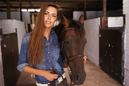 牧童与牛犊女孩最好的朋友 一个年轻女人在照顾她的马匹农场爱好闲暇牛仔关爱长发良种享受幸福成人背景