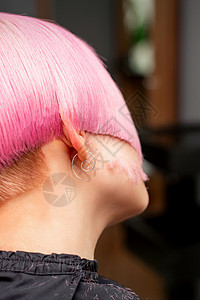 剪短发的女孩在美发沙龙中为年轻模特的后视造型和剪染的粉红色头发 粉色短发理发理发师发型化妆品理发店美丽女孩女性工作室工作背景