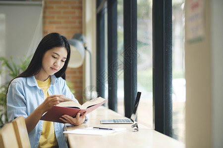 年轻的亚洲女人坐着看书沉思思维学生女士学校知识考试项目图书馆专注背景图片