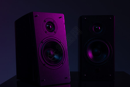 带有紫色大气照明的黑色背景上扬声器系统的图像照片背景图片
