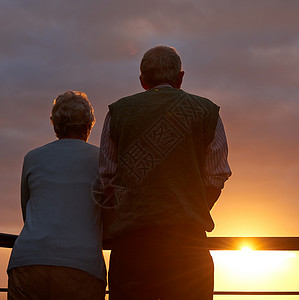 一对年老的夫妇一起看日落的回视镜头 拍下一对年长的情侣背景图片