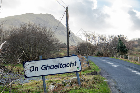 一个路标解释说这里开始了一个讲爱尔兰语的区域-翻译 爱尔兰语背景图片