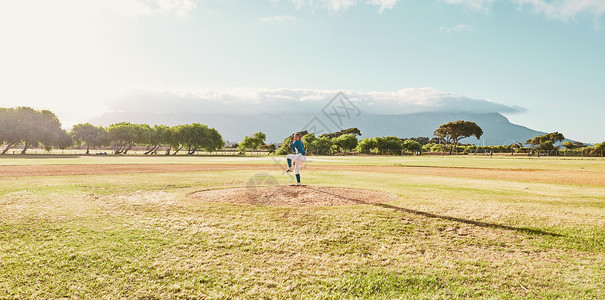 垒球投手一场棒球比赛的投手全景 准备投球和投球 棒球运动员独自站在棒球场的投手丘上进行练习 训练和体育比赛背景