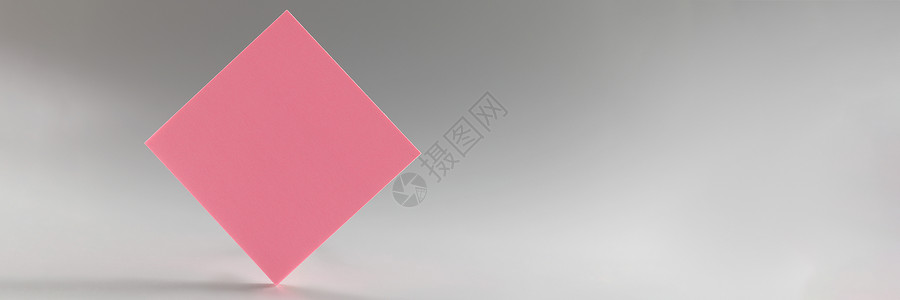 粉红贴纸站在灰色背景的尖边缘背景图片
