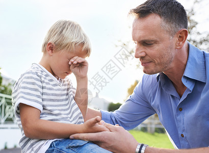 我的孩子会没事的 一个父亲安慰他哭着的男孩背景图片