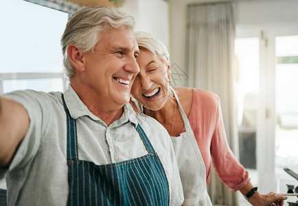 在有趣的时刻一起做饭 烘焙或打扫卫生时 老人 情侣和在家自拍很开心 年长的男人 女人和退休人员在厨房里大笑 亲近和微笑 做饭和开背景图片