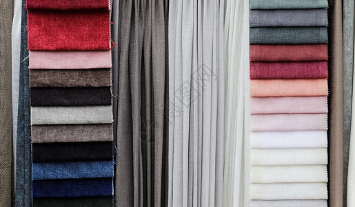 在织物市场上发现的不同颜色的布料和织物样品的详细特写视图样本桌布折痕衬衫店铺纺织品牛仔裤商业布样裙子背景图片