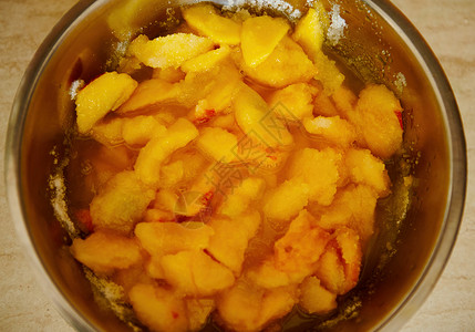 高糖水果高角视图将桃子切成金属碗中的糖 准备自制果酱 罐头食品背景