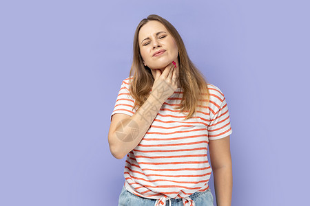 女人触摸她的脖子 喉咙痛 病毒感染或流感症状伤害疼痛卫生扁桃体炎女性痛苦吞咽紫色触诊节点背景图片