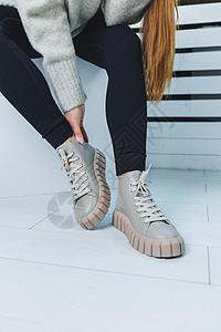 提鞋子女孩特写在时髦的白色鞋子的腿 天然皮革女鞋系列 女式冬靴女孩女性收藏工作室女士蕾丝购物靴子鞋类魅力背景