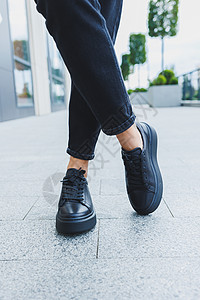 穿黑色牛仔裤和黑带鞋的女子腿 黑皮鞋紧贴季节女孩鞋类店铺工作室女性女士衣服购物中心房间背景图片