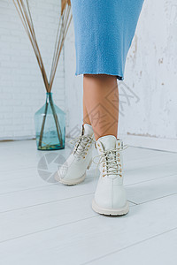 特写在时髦的白色鞋子的腿 天然皮革女鞋系列 女式冬靴购物收藏女性季节配饰奢华靴子工作室商业鞋类背景图片