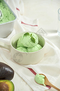 白绿色菜单白盘上的阿沃卡多冰淇淋球 白底的勺子绿色桌子食物菜单味道薄荷水果甜点背景