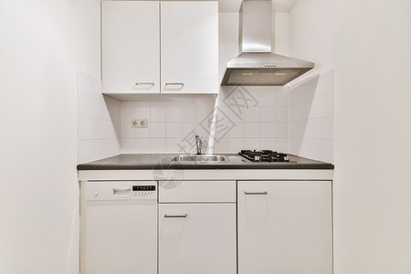 一个厨房 有白色的柜子和一个水槽和炉灶高清图片