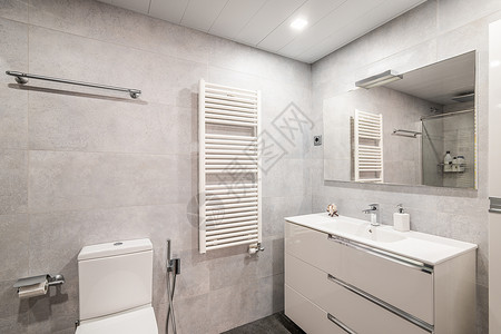 现代风格的宽敞浴室 拥有美丽的内饰和天花板上的灯 新装修的房间 瓷砖墙壁和灰色大理石地板 白色的家具和室内细节背景图片