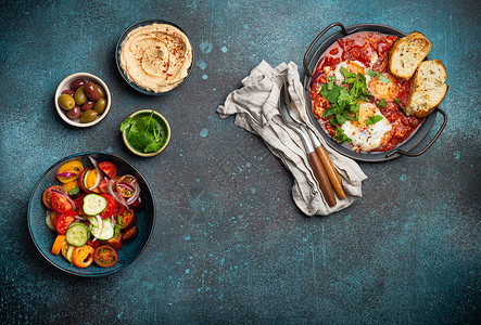 阿拉伯食物中东早餐或早午餐 与Shakshouka 吐司 蔬菜沙拉 hummus 橄榄复制空间香菜盘子乡村美食餐厅平底锅食物面包鹰嘴菜单背景