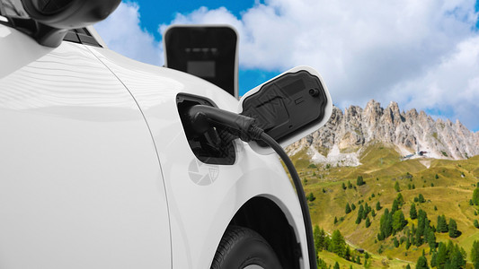 由EV车在边远山上带充电站的渐进旅行概念发动机引擎旅行生态活力电池天空汽车驾驶高山背景图片