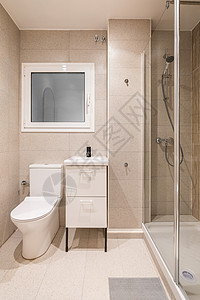带透明玻璃墙的小淋浴区的浴室 家具上的洗脸盆 带浴室配件抽屉 墙上的窗户有磨砂玻璃和白色框架图片