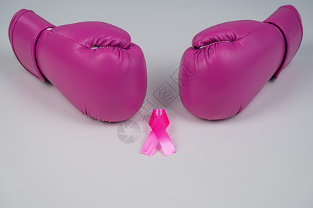 粉色拳击手套和白色背景的粉红色丝带 乳腺癌概念警觉帮助保健攻击女性作品癌症药品斗争照片背景图片