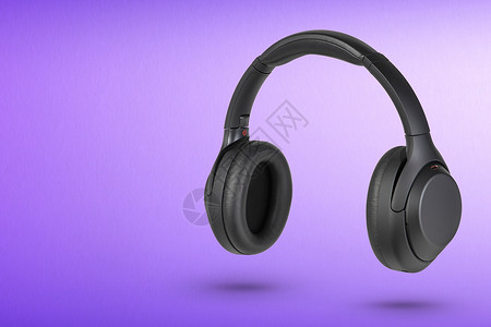 紫色背景上的耳机 黑色无线耳机 高品质 用于广告或产品目录背景图片