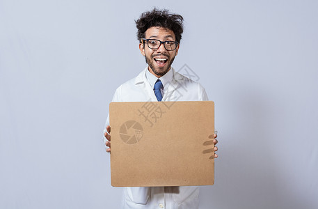 一位身穿白大褂的科学家拿着一张空白的剪贴板 科学家展示并指着一个空白的剪贴板 身穿白大衣的教授拿着并展示一个孤立的空白剪贴板背景图片