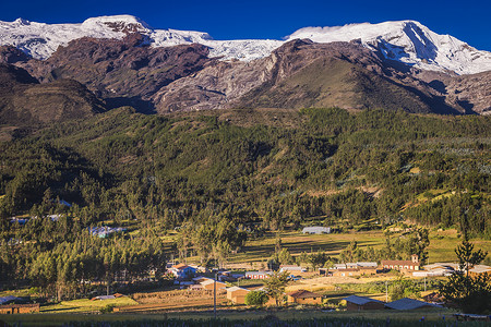 瓦斯卡日出时在的Hascaran村和Huascaran村下雪山脉旅游日落目的地风景城市农场教会雪山地标背景