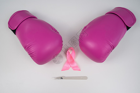 十月一活动粉色拳击手套 手术刀和白色背景上的粉色丝带 抗击乳腺癌的概念预防手术丝绸攻击防御保健斗争胸部女性女士背景